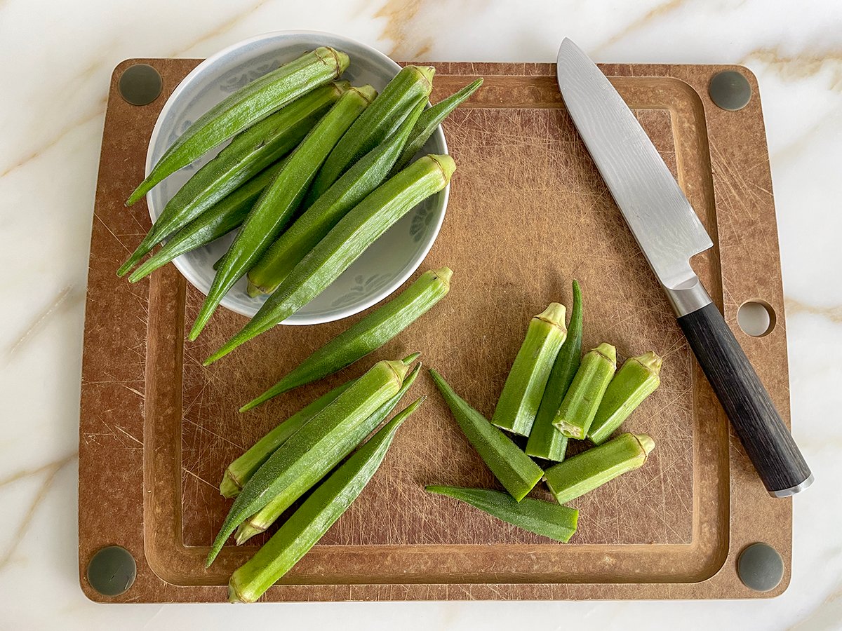 okra on a cutting board with a knife