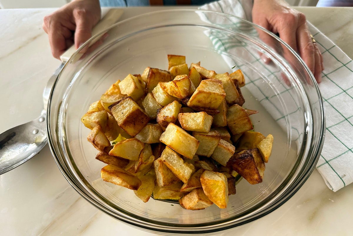 roasted cubed potatoes in a glass bowl