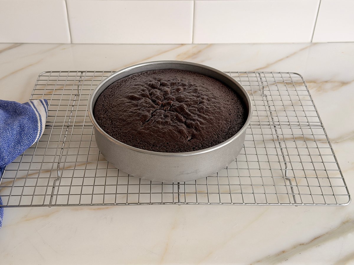 Baked chocolate cake in a pan on a wire rack