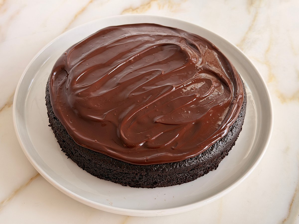 Round frosted chocolate cake on a round white platter