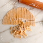 noodles cut from a rolled dough with a wood rolling pin on the side