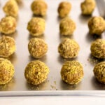 green pistachio coated energy bites on a sheet pan