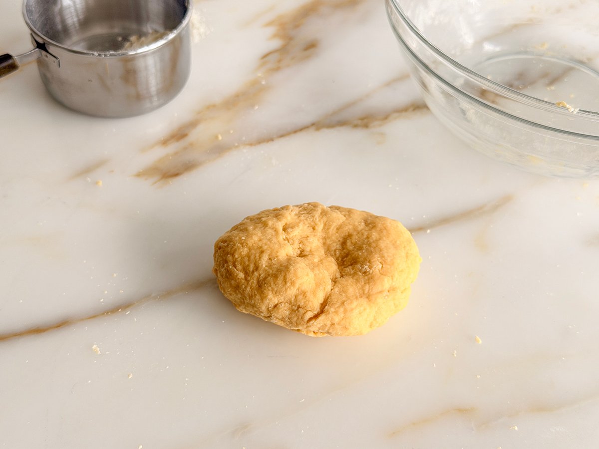 a ball of pasta dough on a marble counter