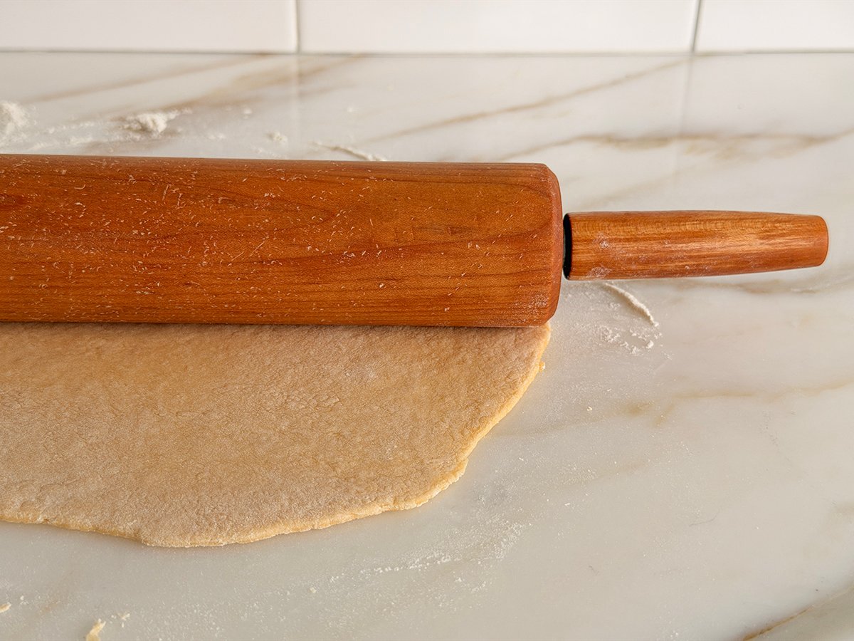 rolled dough close up with a wood rolling pin on top
