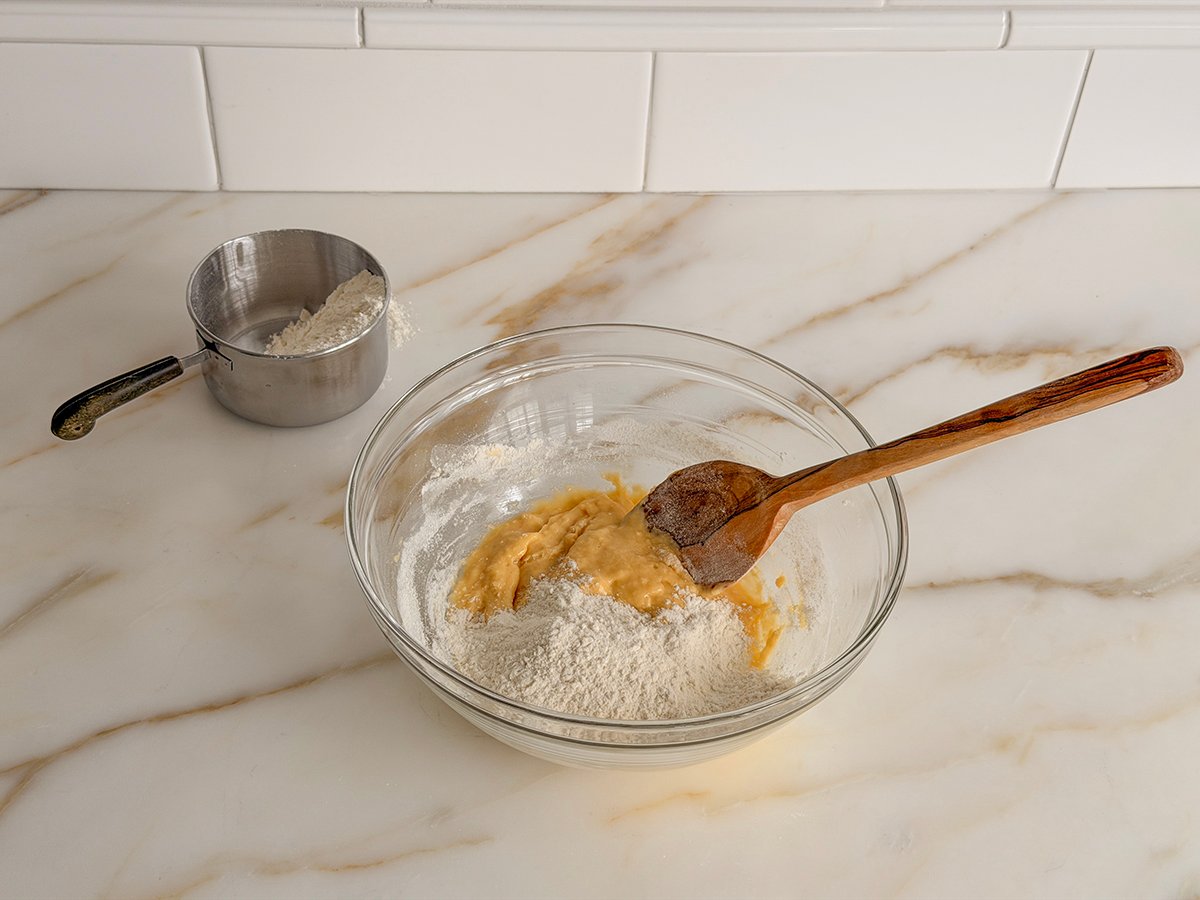 a glass bowl with flour and eggs in it