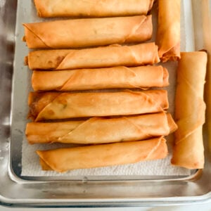 Golden cheese rolls on paper towel on a baking sheet