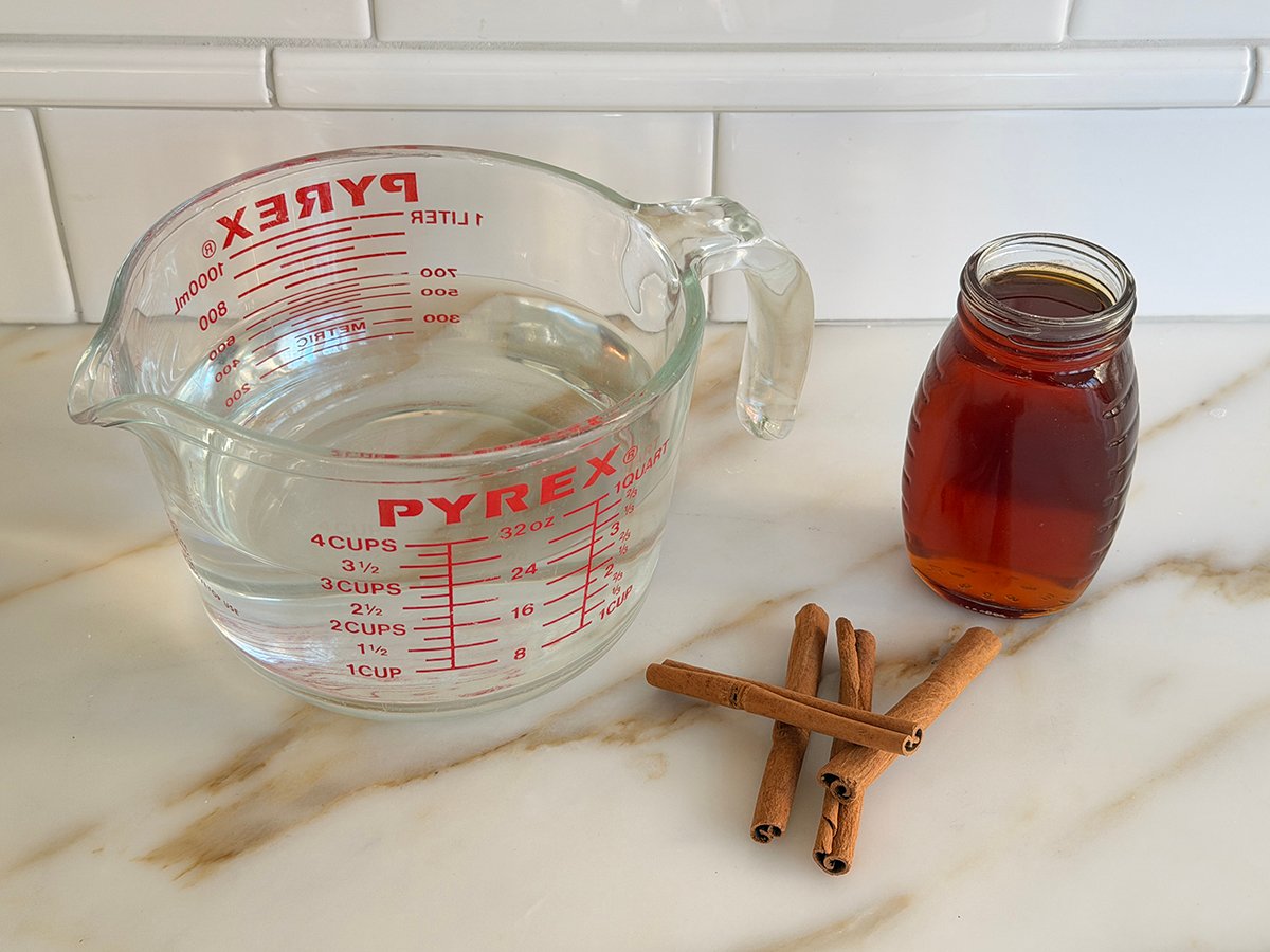 Ingredients for cinnamon tea on a marble countertop