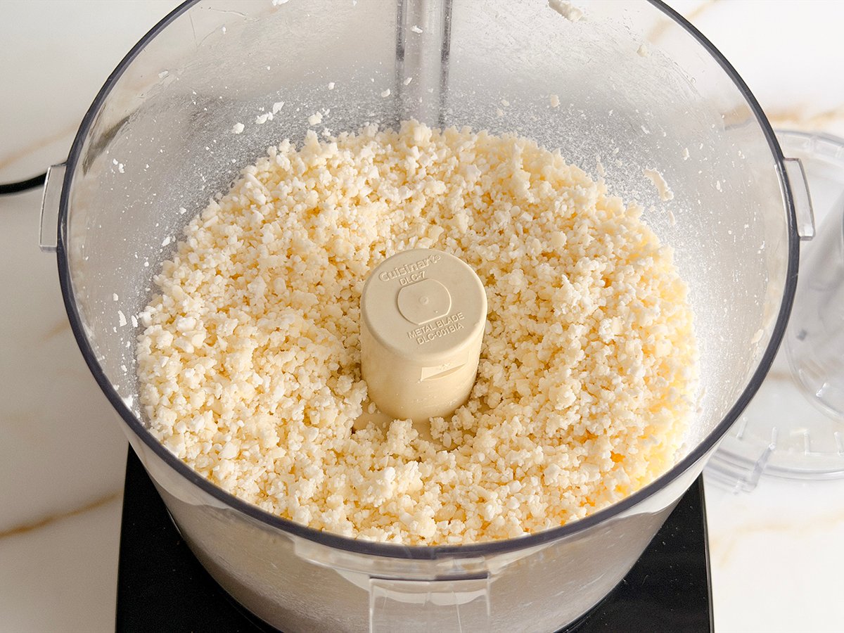 ground white cheese in the bowl of a food processor