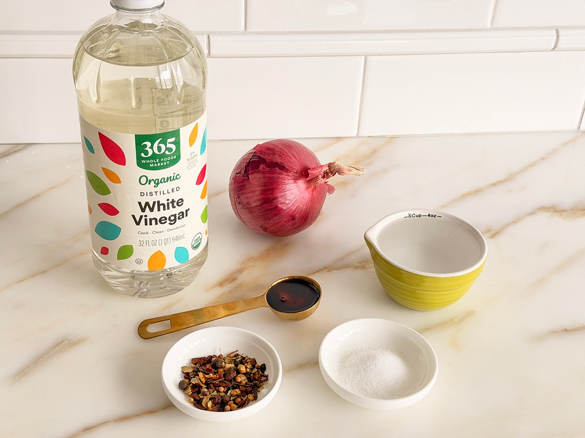 Ingredients for pickled onions on a marble counter