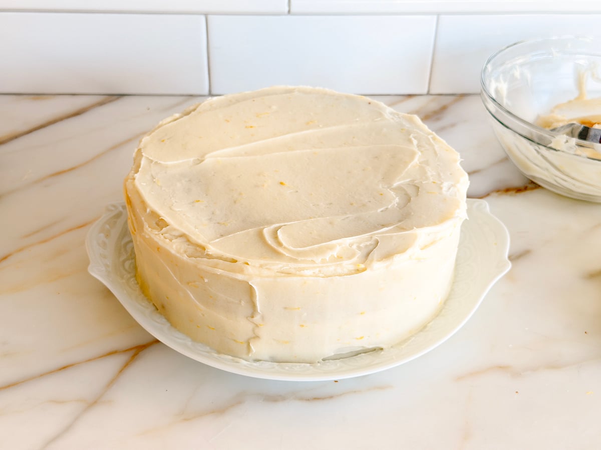 Frosted white cake on a white platter