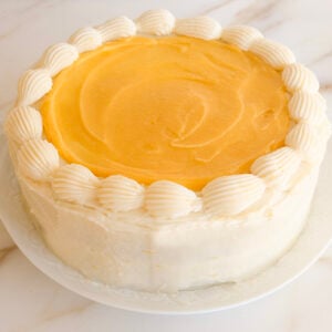 Lemon cake with lemon curd on top and a piped shell border