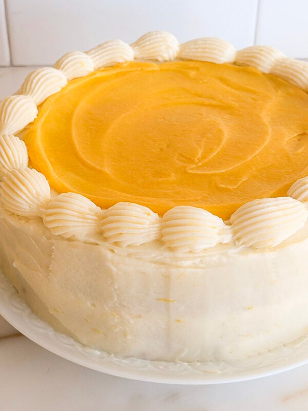 Lemon cake with curd on top and lemons in the background