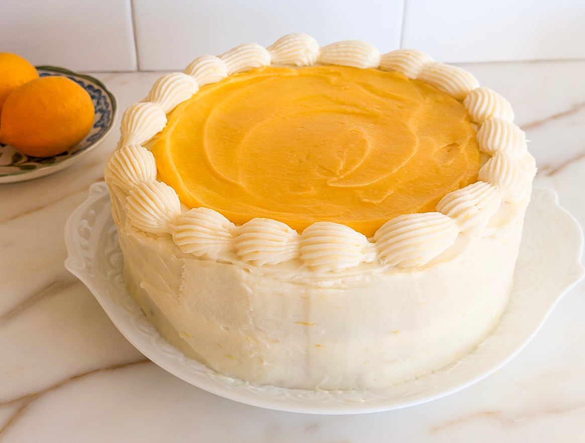 Lemon cake with curd on top and lemons in the background