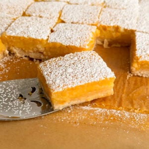 Lemon bar with powdered sugar on a metal server