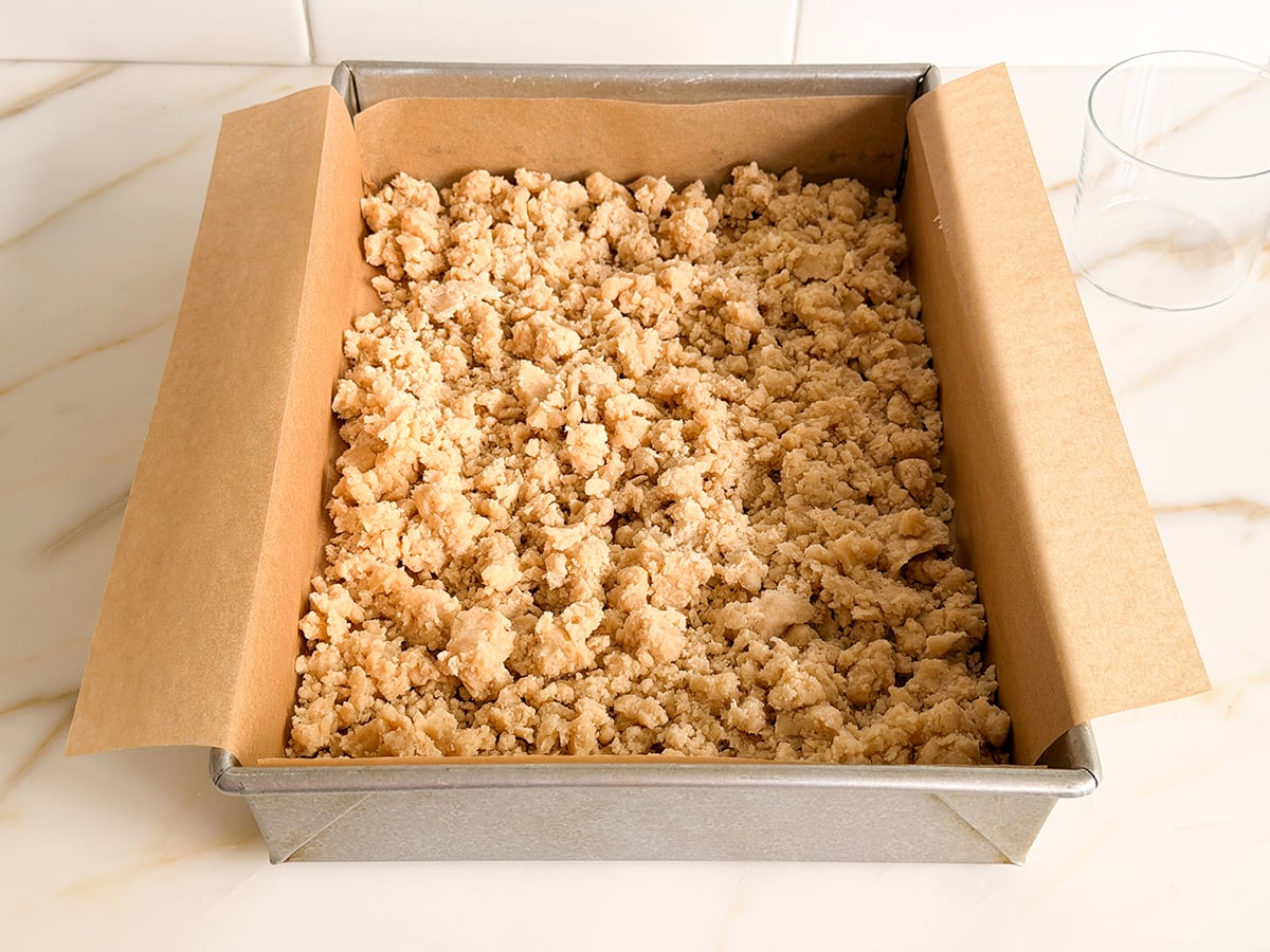 Crumbled dough in a parchment-lined pan