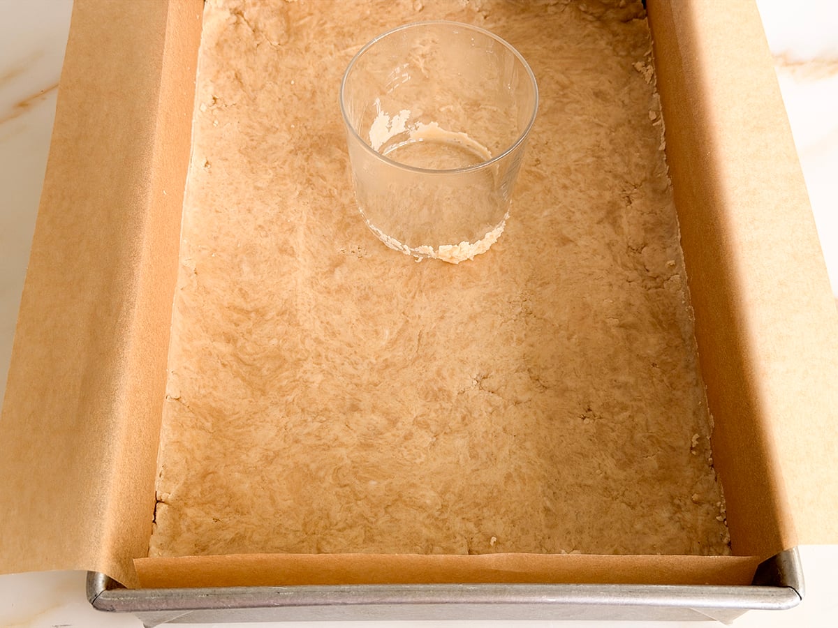 A flat-bottomed glass on pressed dough in a pan