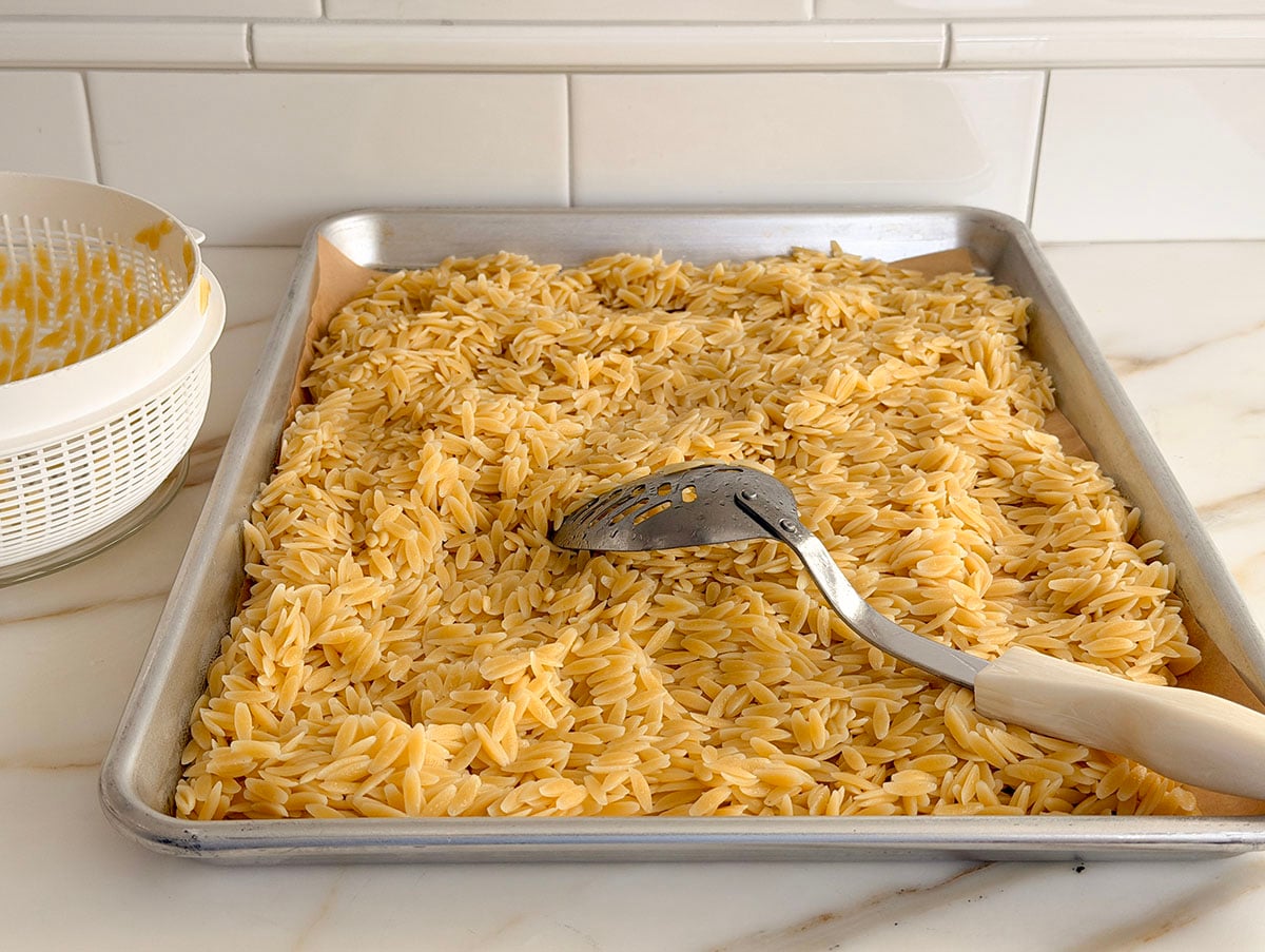 Orzo pasta cooling on a sheet pan