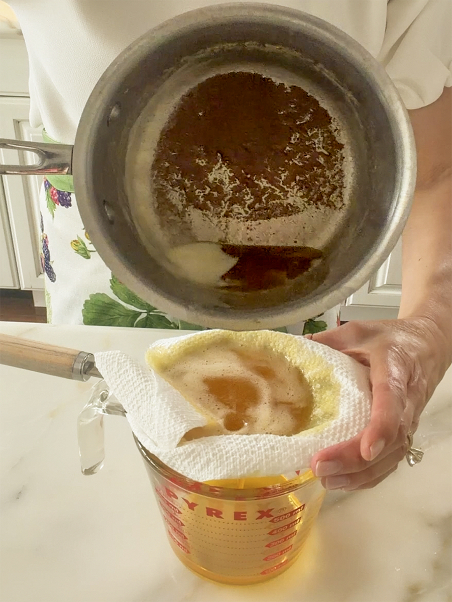 Ghee poured from a pot through a strainer