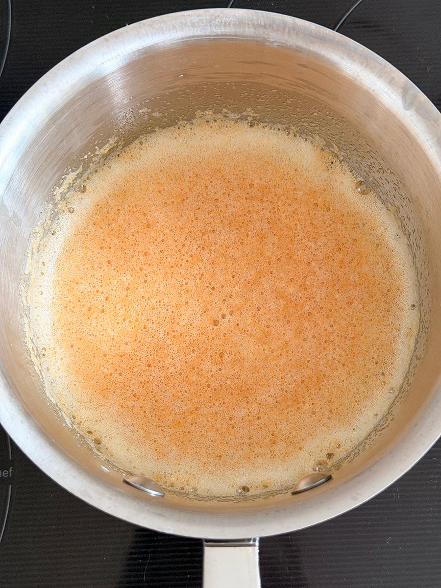 Golden brown foam in a steel pot
