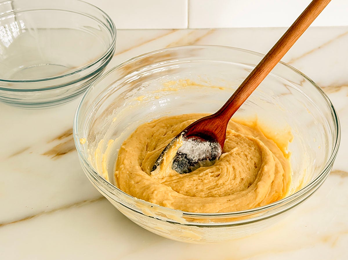 Strawberry muffin batter with a wooden spoon in it
