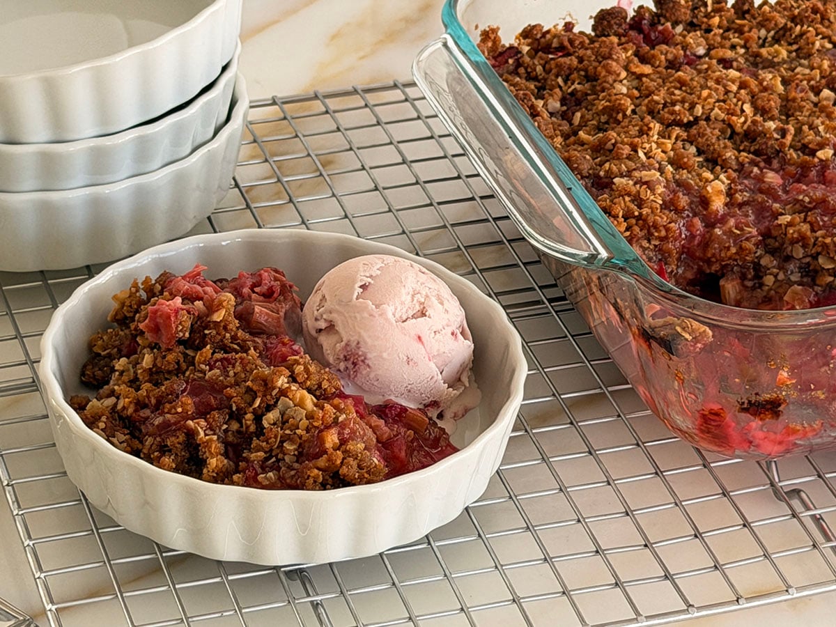 Rhubarb crisp with a scoop of ice cream in a white dish