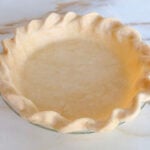 Butter pie crust dough in a pie plate with crimped edges
