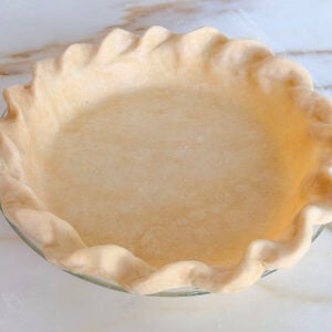 Butter pie crust dough in a pie plate with crimped edges