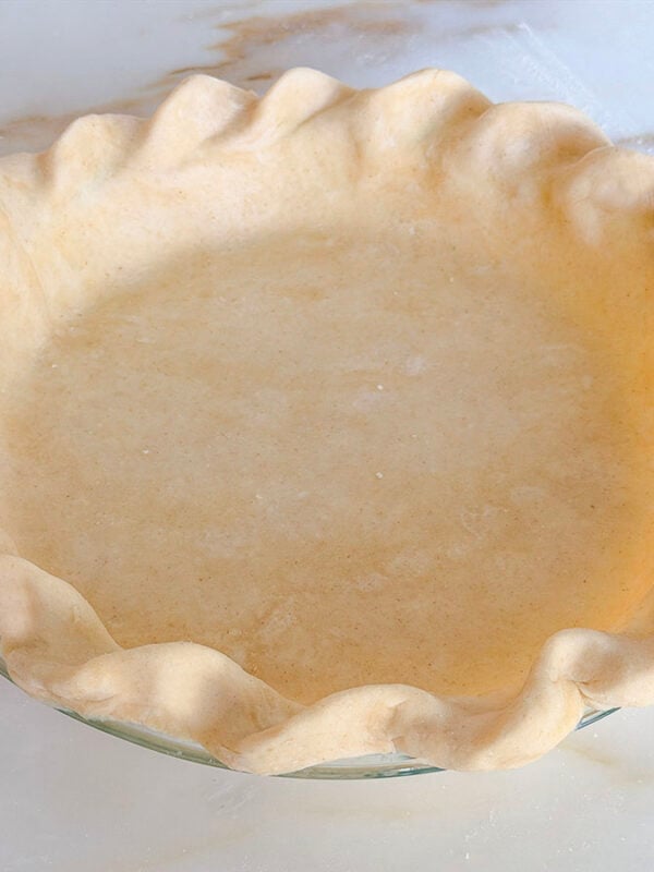 Butter pie crust dough in a pie plate with crimped edges