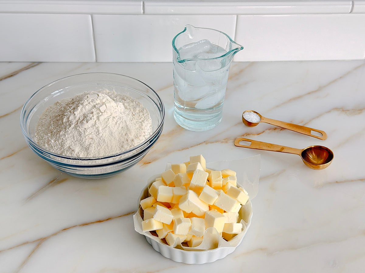 Ingredients for butter pie crust on a marble countertop