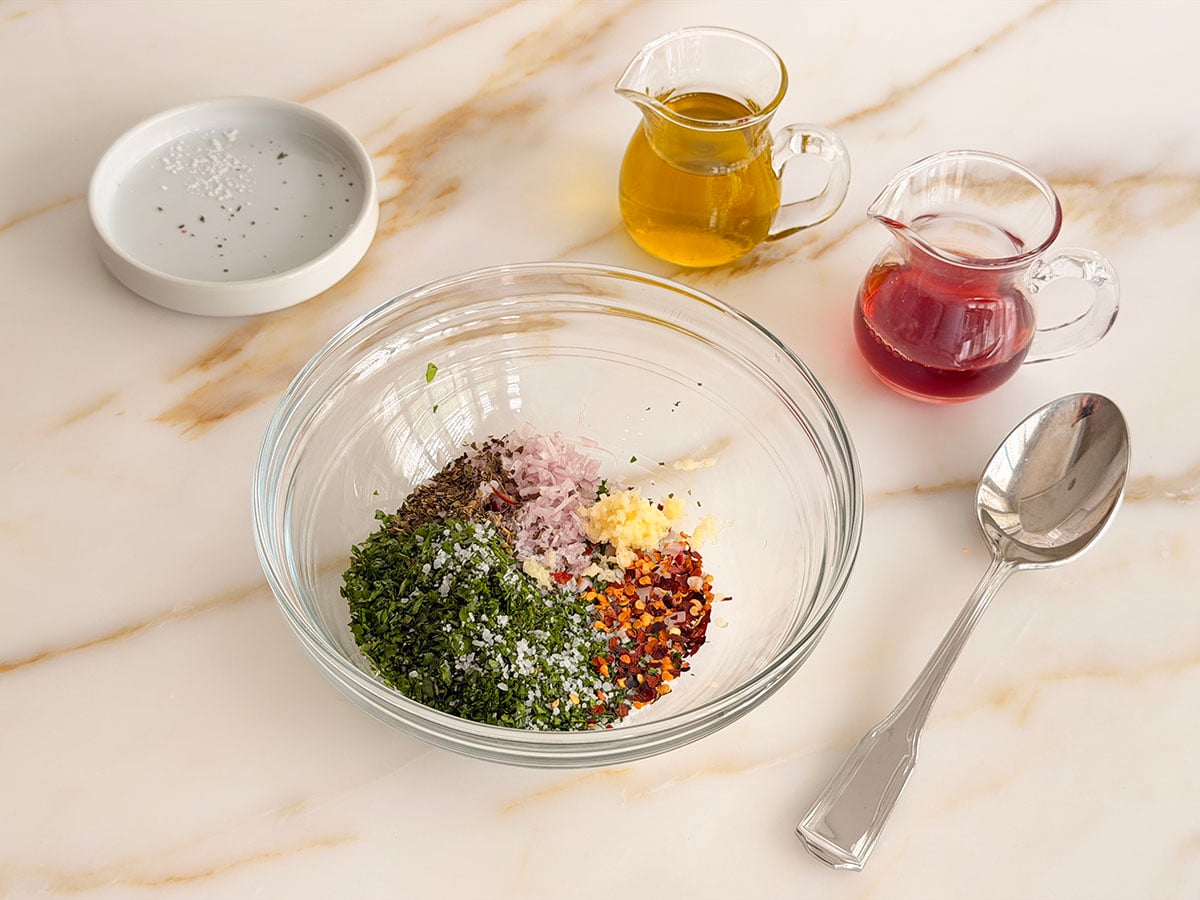 Ingredients for chimichurri in a glass bowl