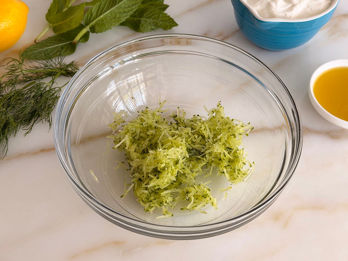 Grated cucumber in a glass bowl