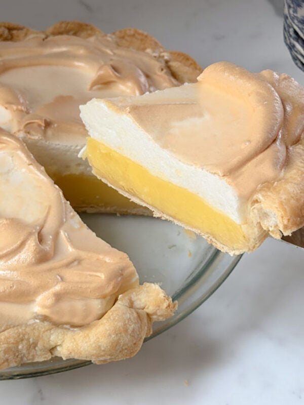 Lemon meringue pie slice lifting from the pie