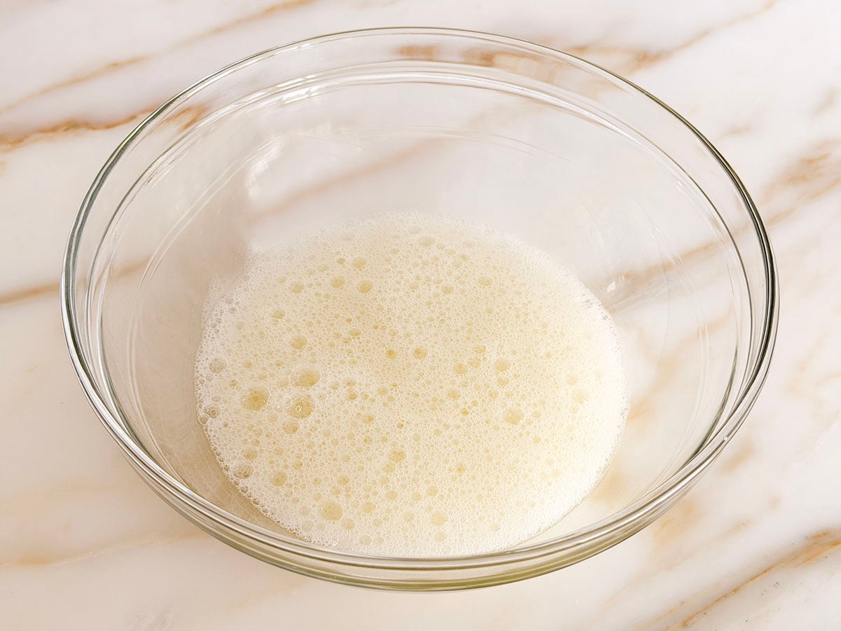 Frothy egg whites in a glass bowl