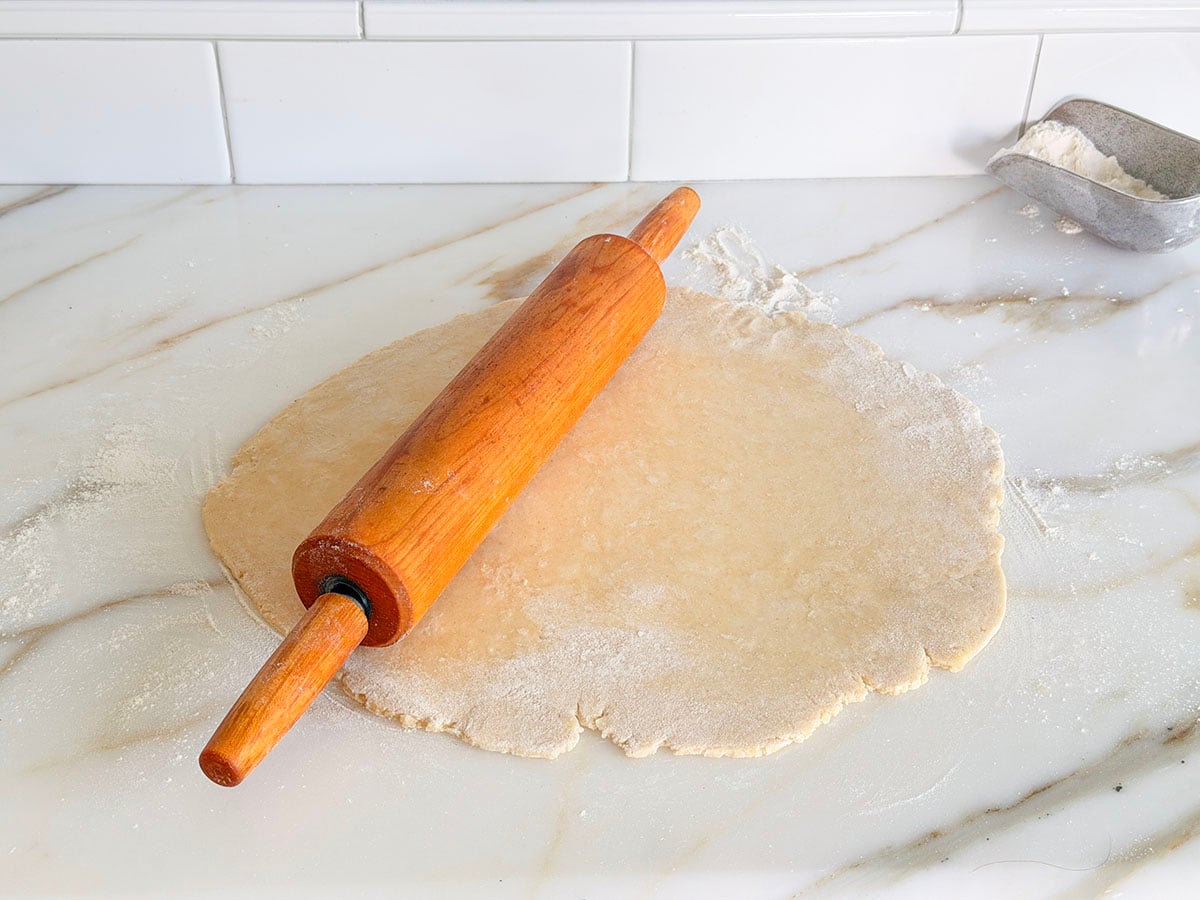 Rolled pie dough with wood rolling pin on top